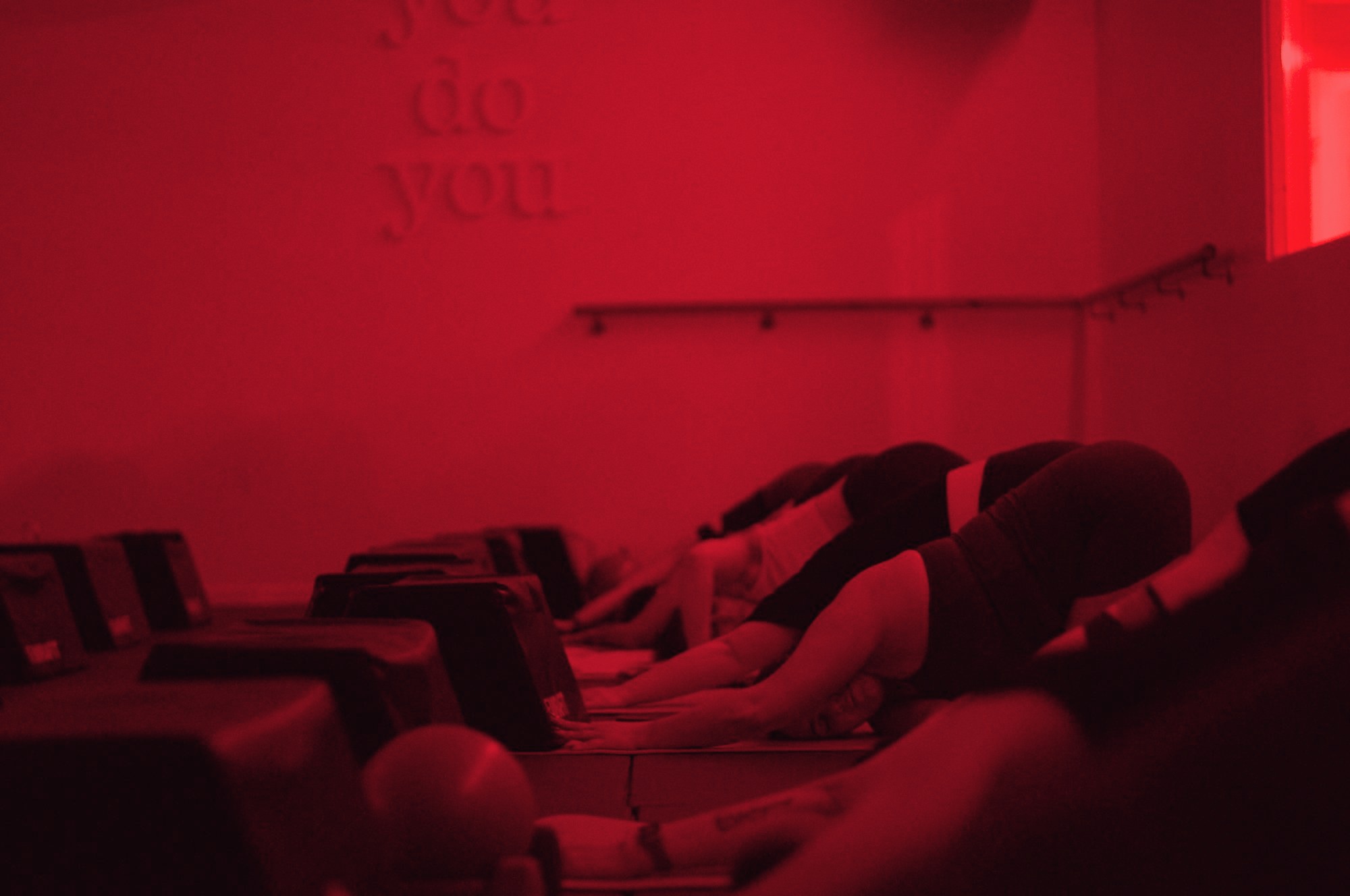 The instructor leading the room from the front under red light