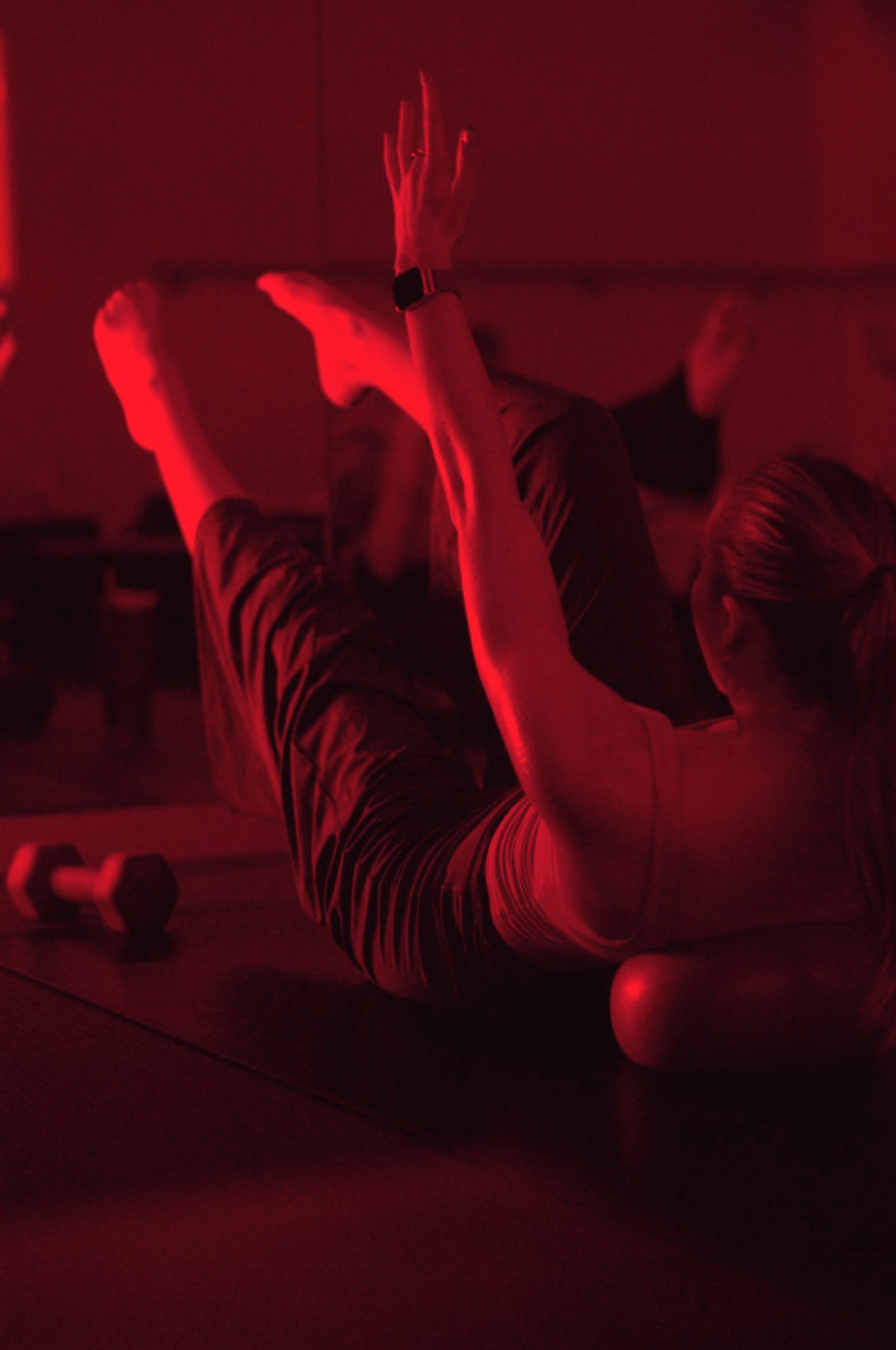 A student stretching a leg skyward on the mat