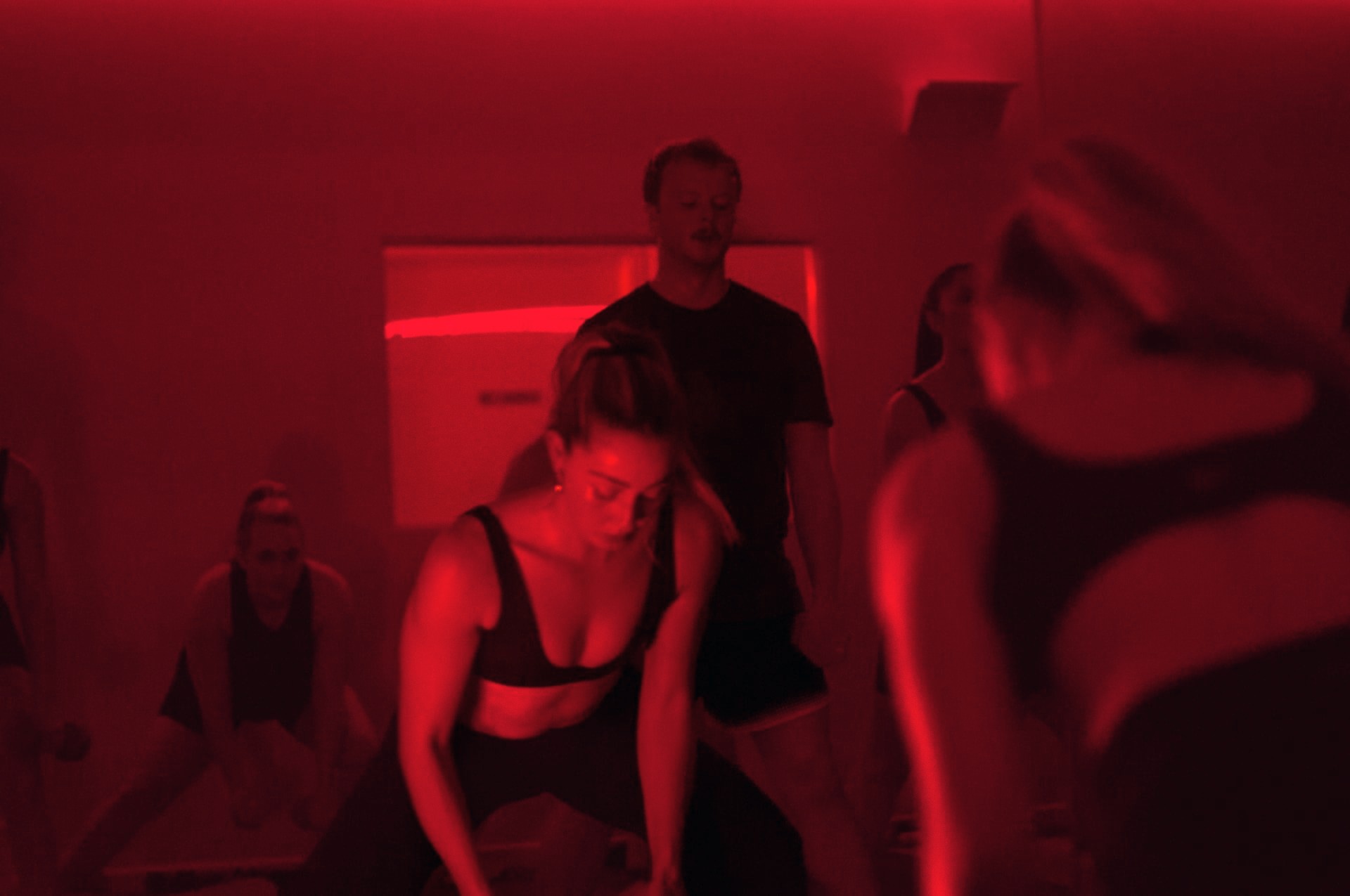 The Hot Pilates group working through a set, a man standing at the back