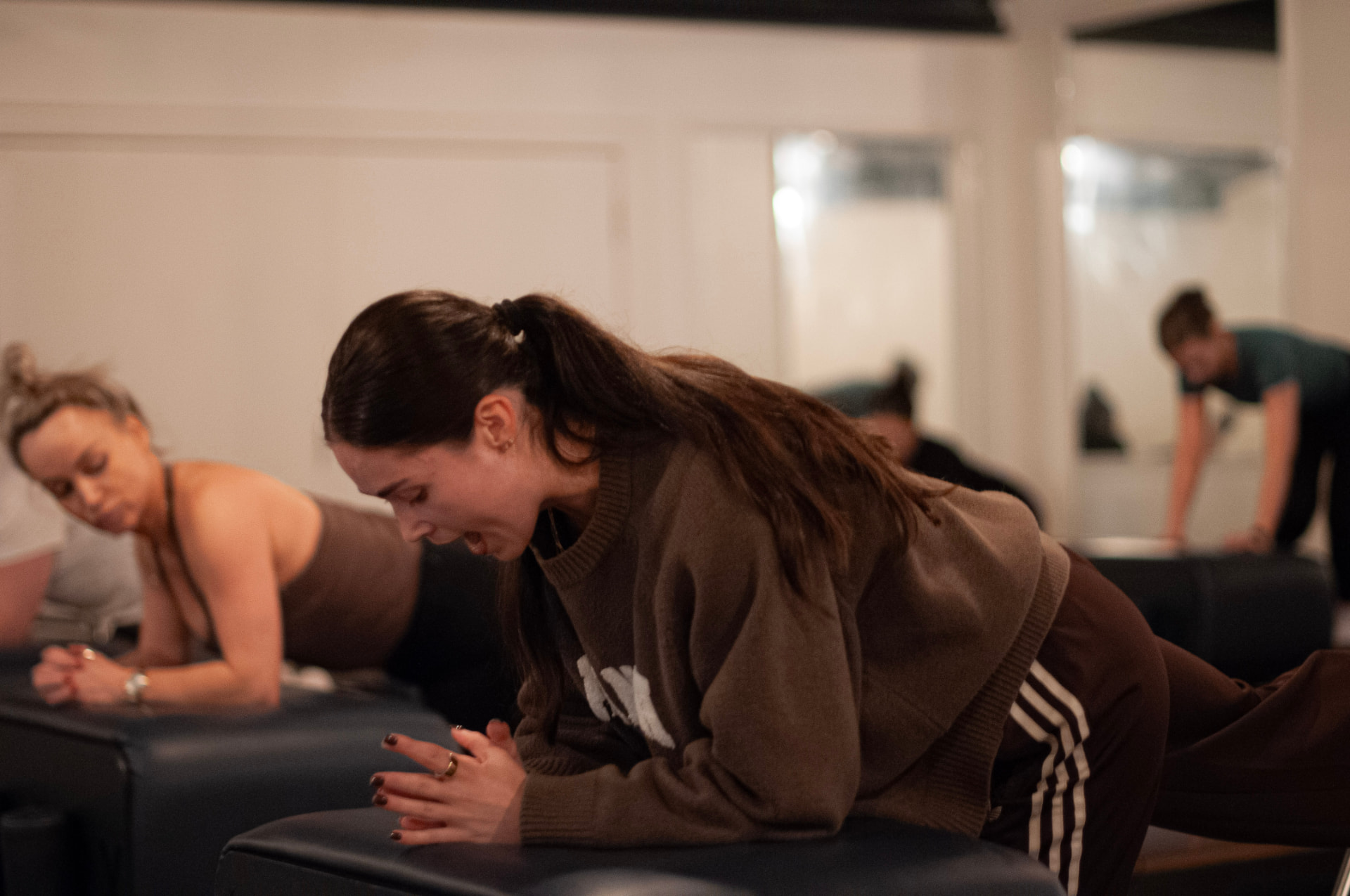 Creina, Reformer and Hot Pilates instructor, coaching over the machines in the bright studio