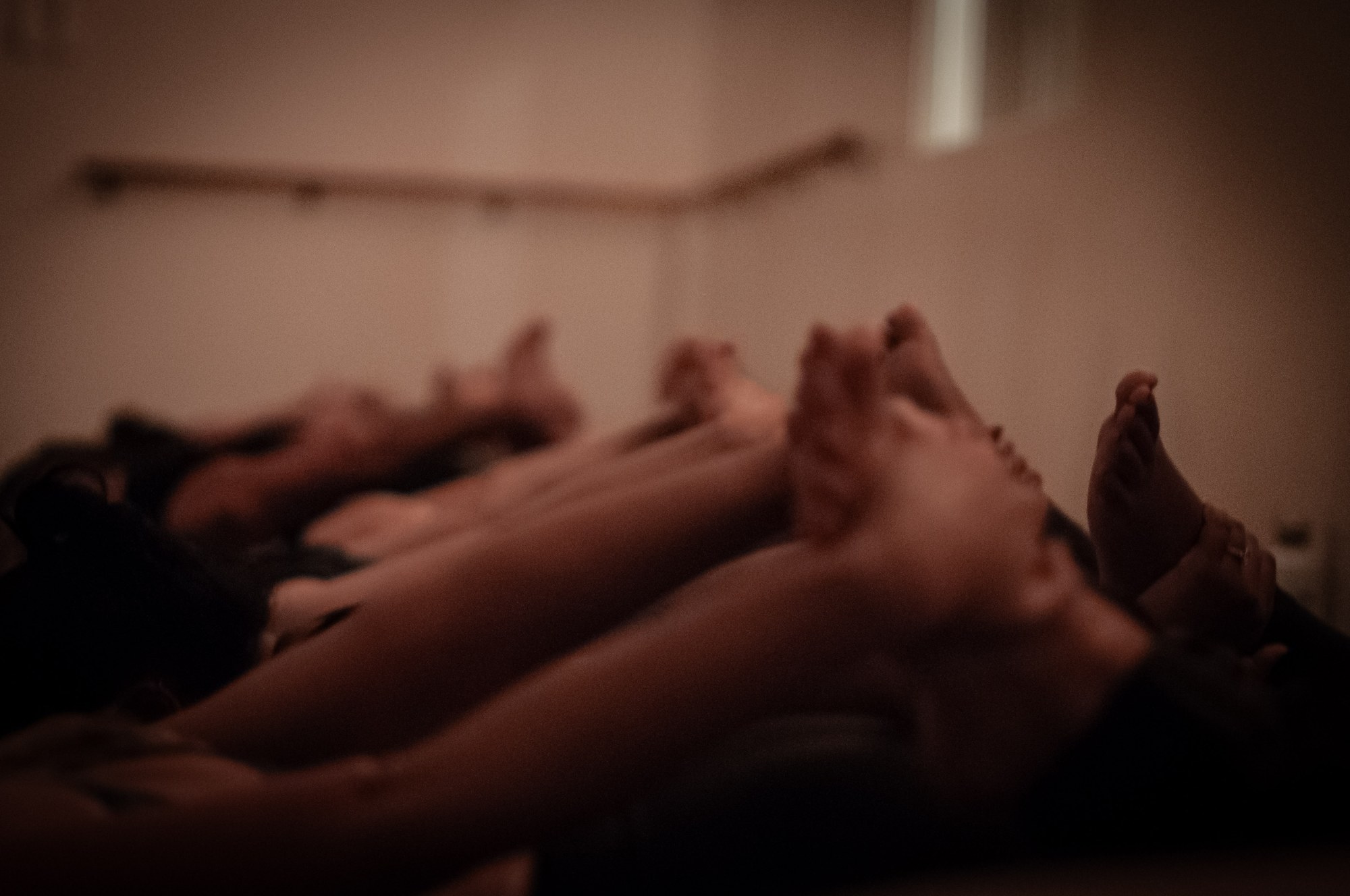 A row of bare feet and legs stretched long along the mats