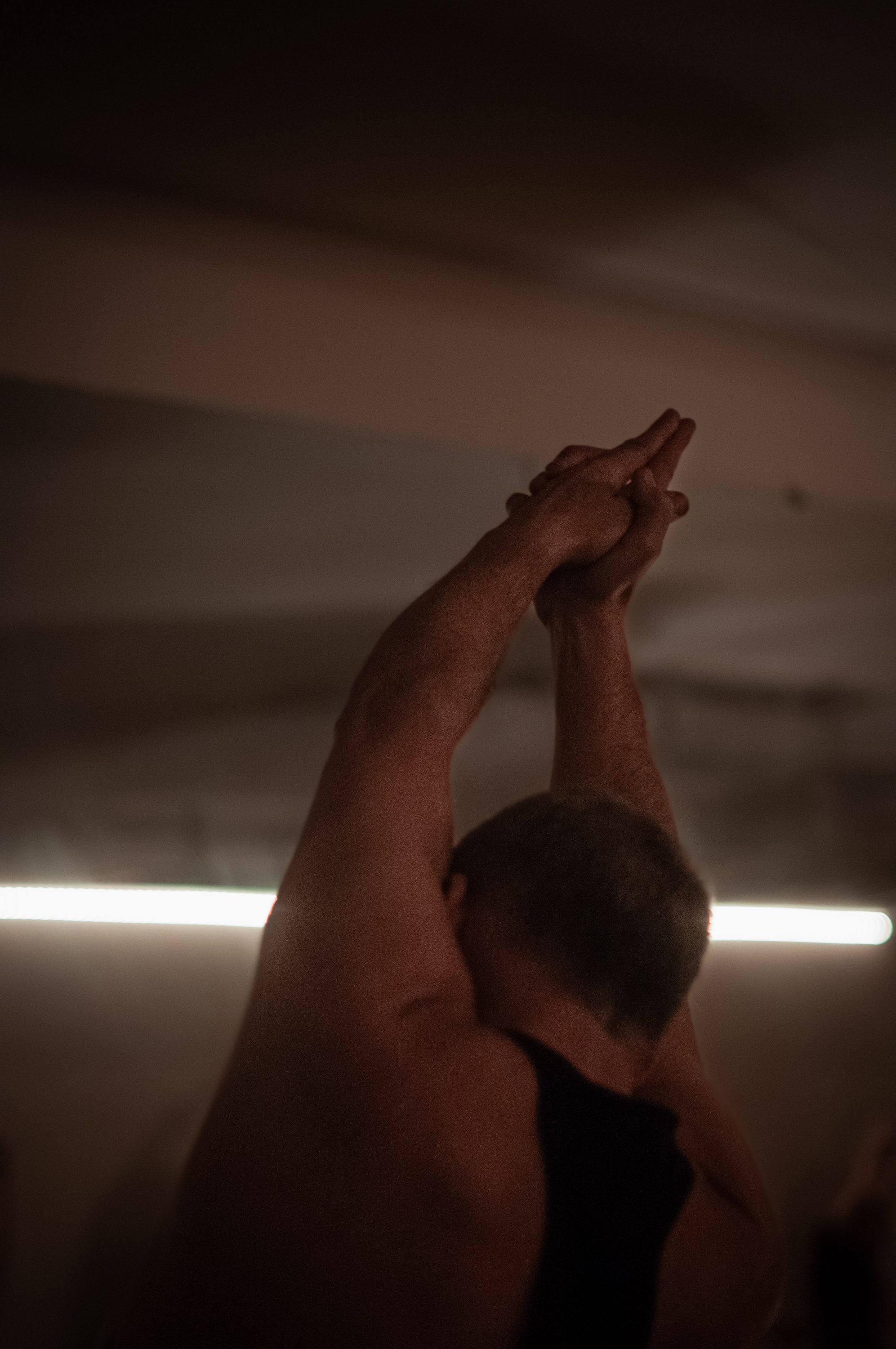A man stretching his arms overhead in Hot Yoga Flow
